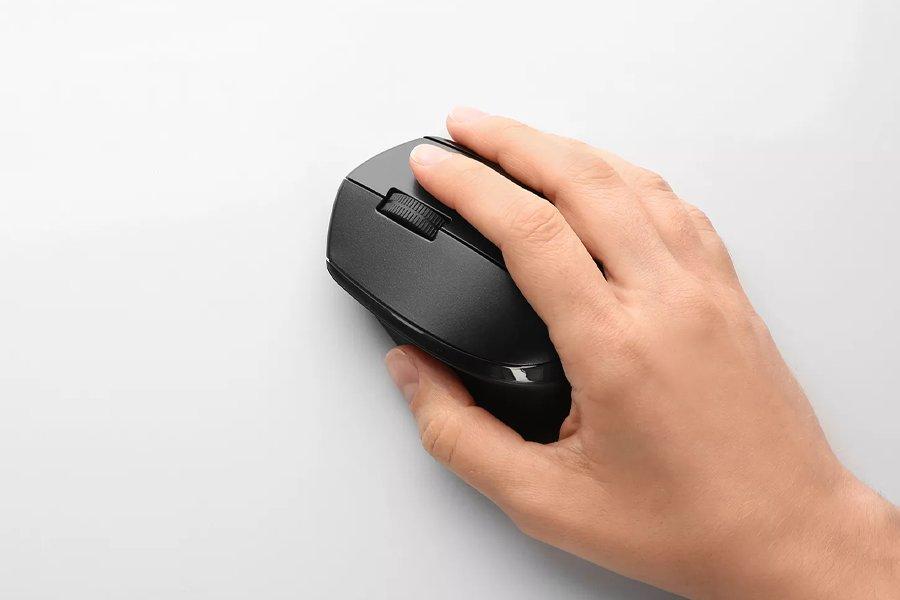 A hand holding a black computer mouse