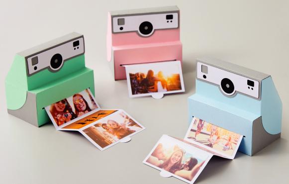 Three cardboard instant cameras