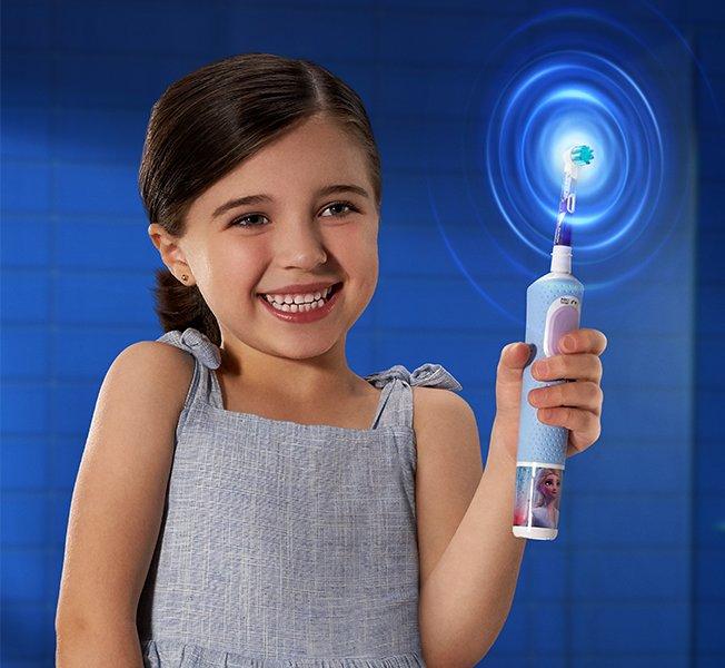 a young boy is brushing his teeth with an electric toothbrush