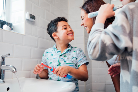 a woman and boy in a bathroom brushing teeth together