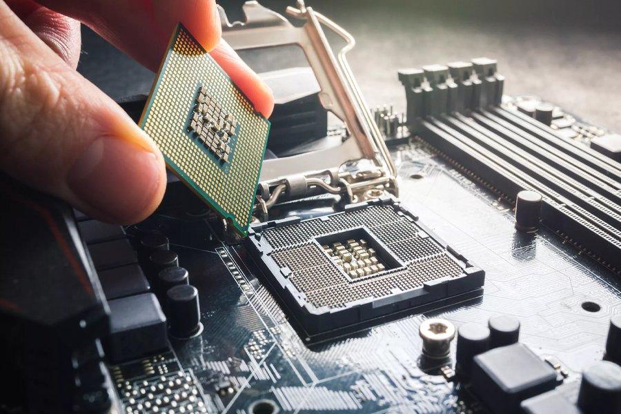 A close up of some fingers putting a processor into a PC