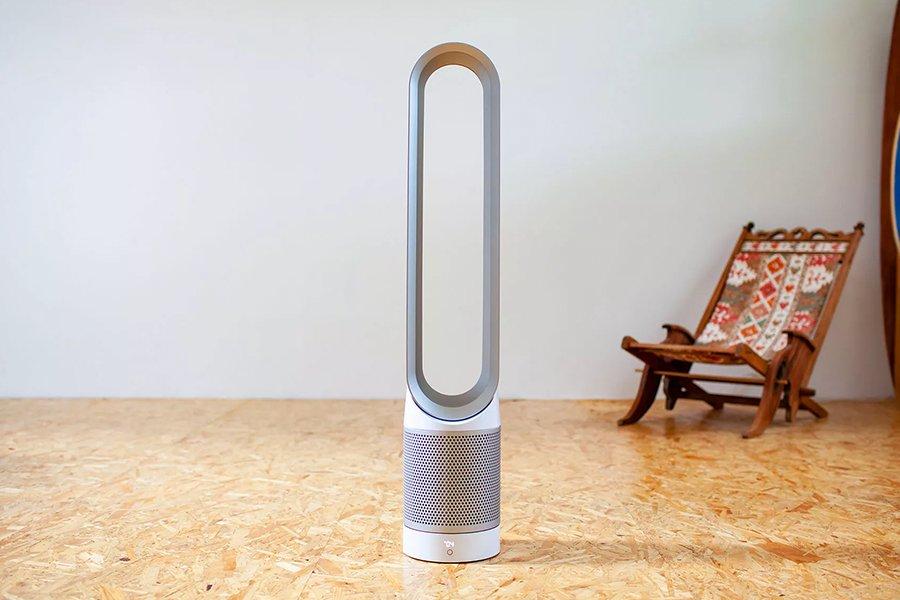 A Dyson fan in the middle of an room with a chair in the background