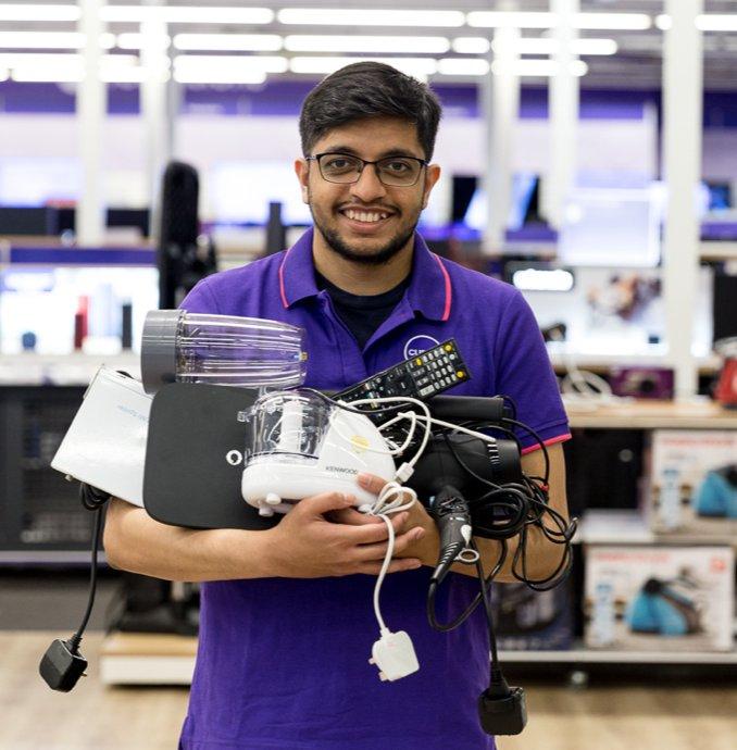a man holding a bunch of electronics in a store
