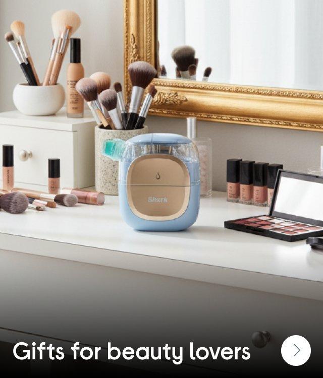 A Shark facial beauty product on a table surrounded by make-up