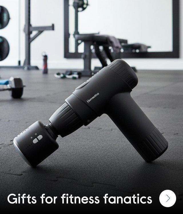 A massage gun n the floor in a home gym