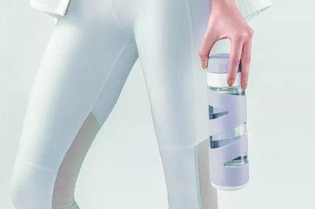 a woman in white pants holding a smart water bottle