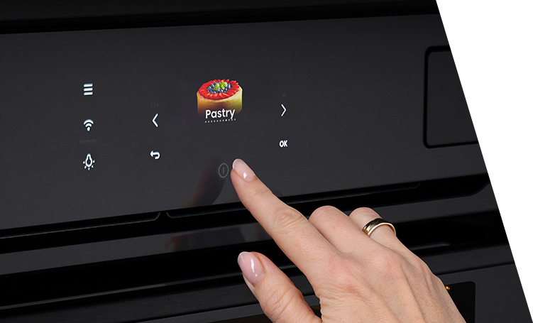 A finger pressing a button on an oven