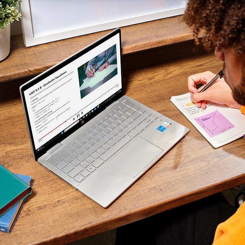 a man sitting at a desk with a laptop open on a table
