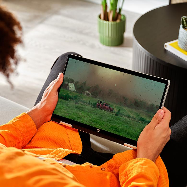 a person sitting on a couch holding a laptop computer