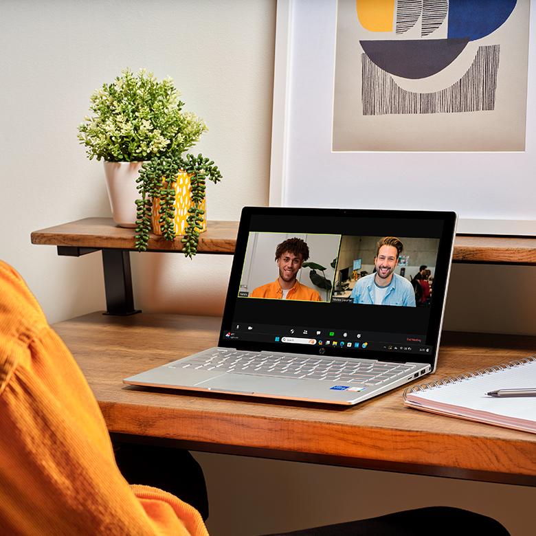a person sitting at a desk with a laptop open on a table