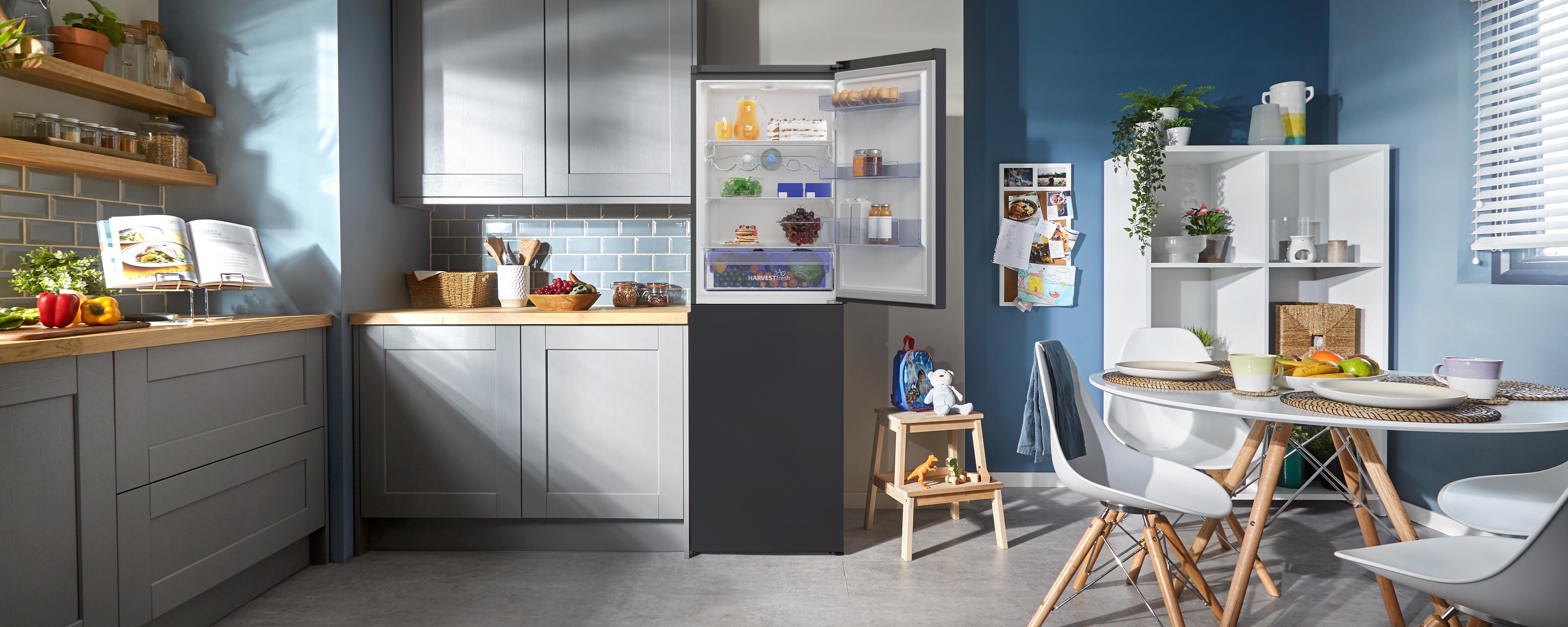 a kitchen with a refrigerator, a table and chairs and a sink