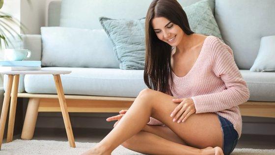 a woman sitting on the floor in front of a rug
