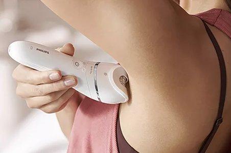 a woman is using an electronic device to remove her hair