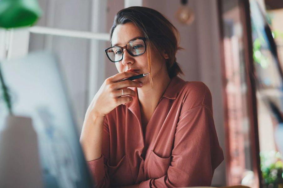 A woman looking at a laptop screen