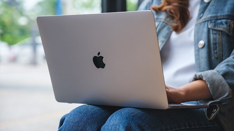 A person with a MacBook on their lap