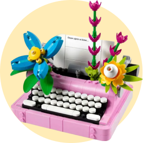 A pink LEGO typewriter with flowers on top 