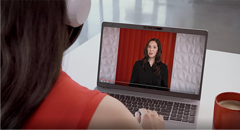 A woman is looking at a computer screen with a picture of a woman on it