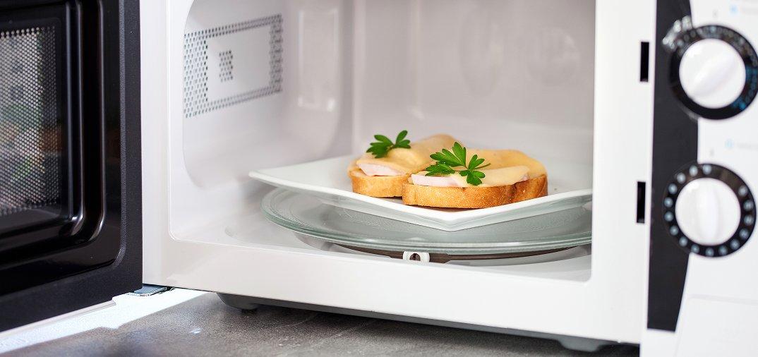 a white microwave with food inside of it and a plate