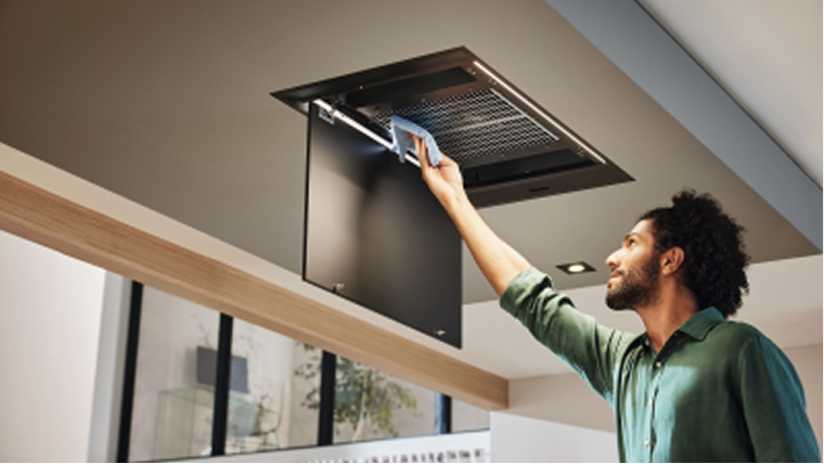 A man opening an overhead hood in a kitchen