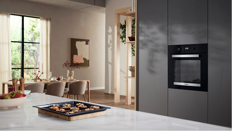 A tray of cookies on a kitchen counter with a built-in oven in the background