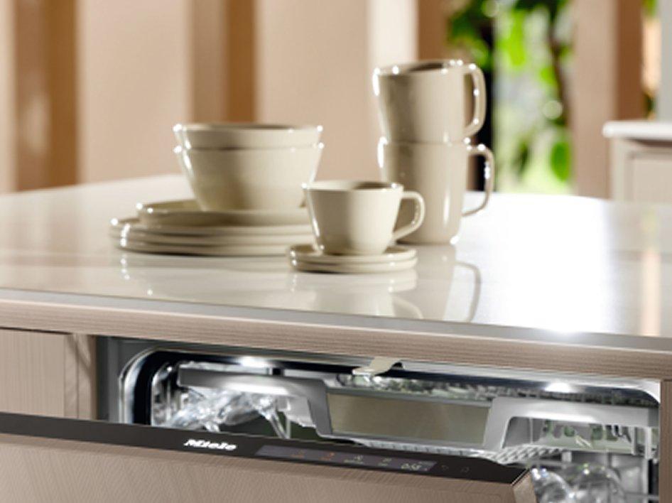 A set of crockery on a kitchen counter next to an open dishwasher