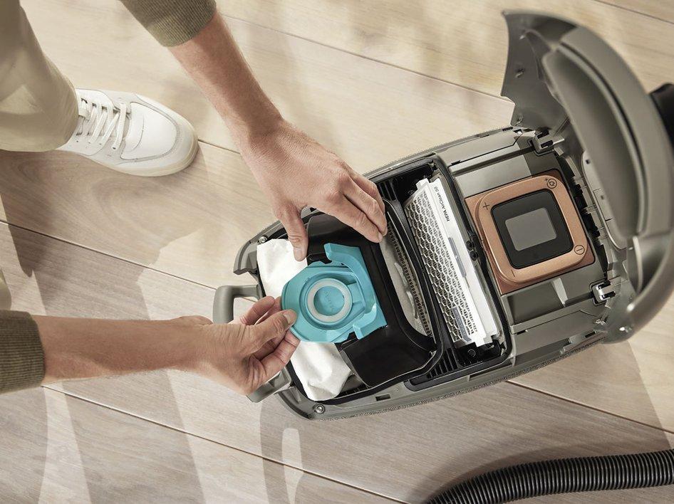 A person taking the bag out of a vacuum cleaner