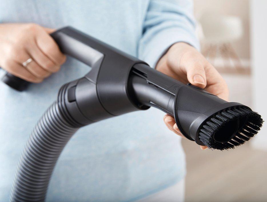 A person holding a vaccuum cleaner end