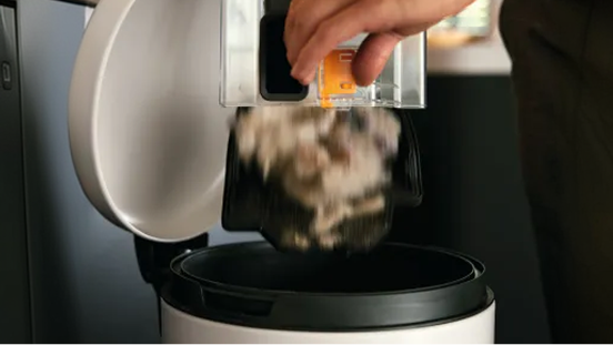 A vacuum cleaner bag being emptied into a bin