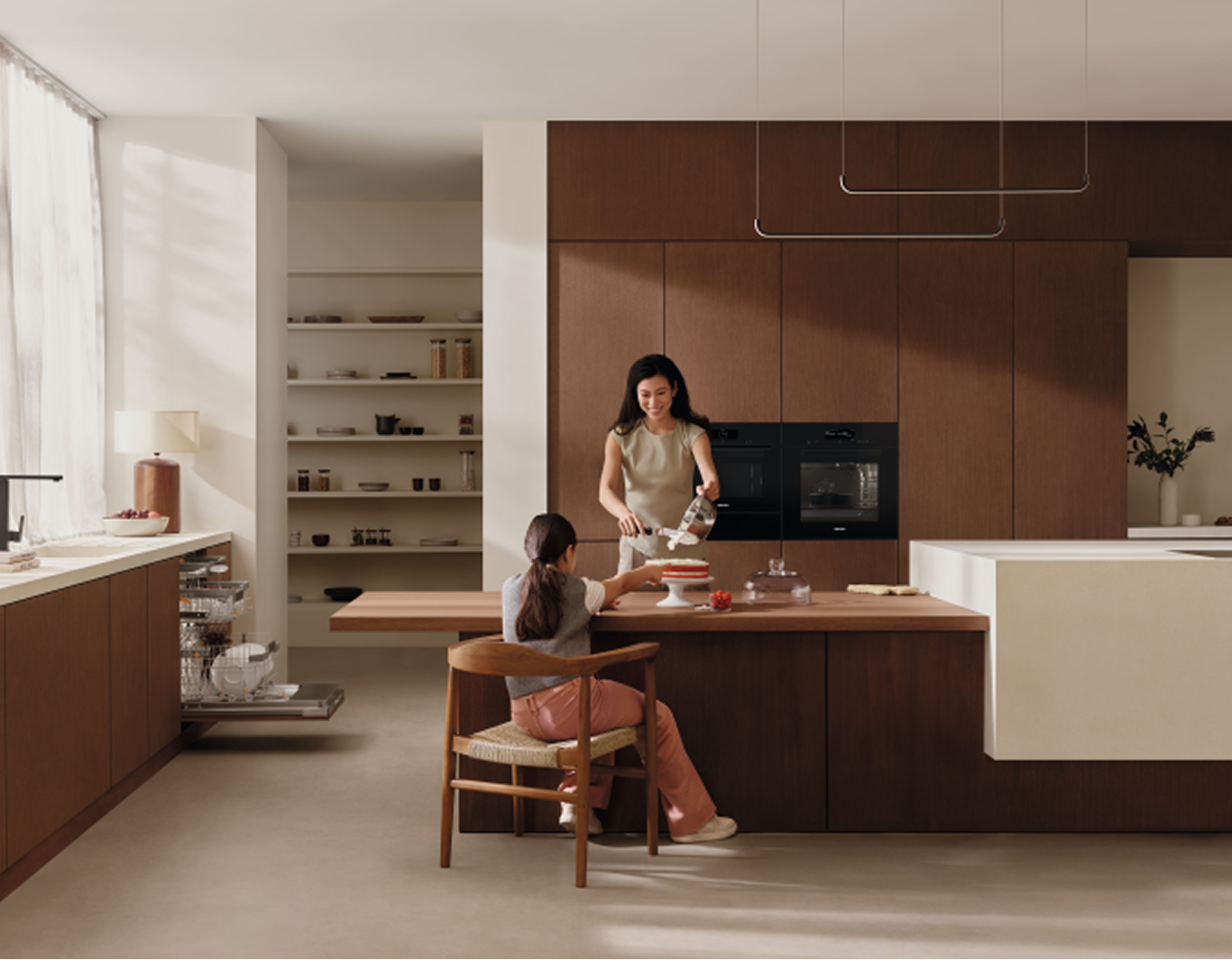 A woman and a child are sitting in a kitchen plating a cake