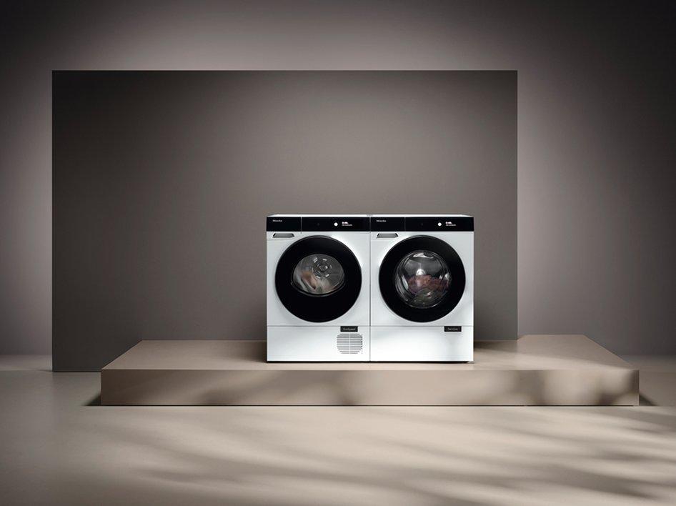 Two laundry machines on a stand
