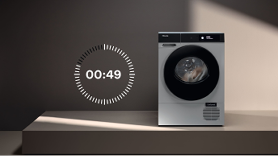 A washer dryer on a stand with a countdown timer next to it