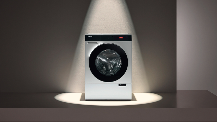 A washer dryer on a platform lit by a spotlight