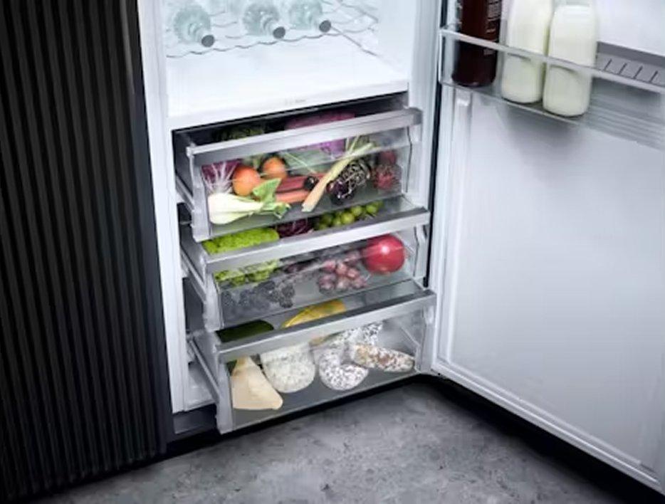 An open fridge with drawers at the bottom