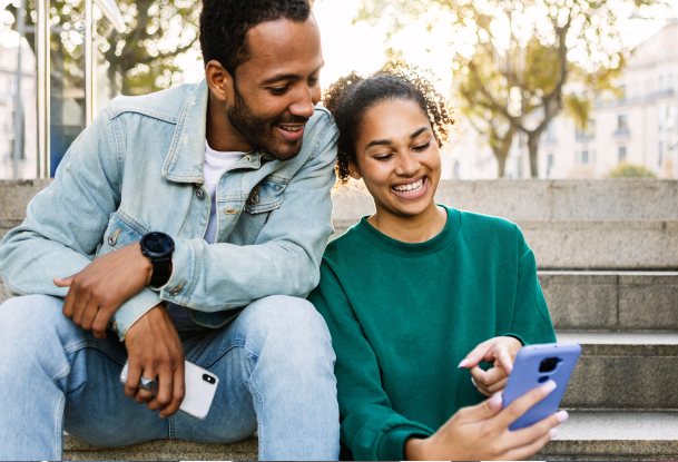 A man and woman looking at a smart phone that she's holding