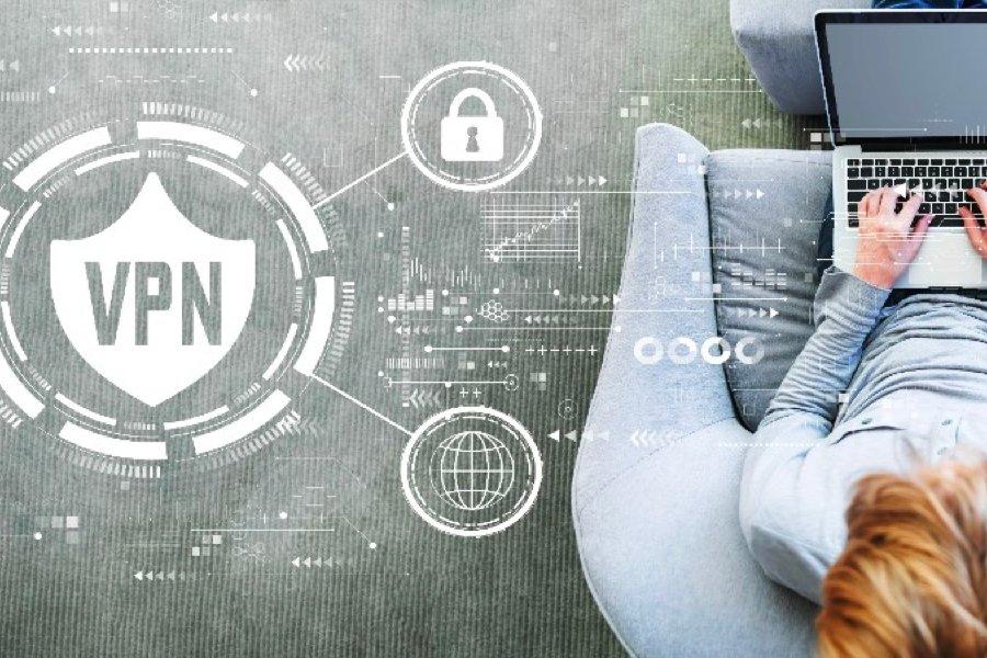 a woman sitting on a laptop with a vpn icon on the screen