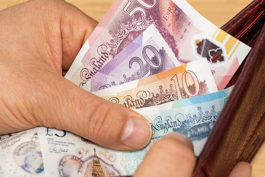 A hand taking money out of a wallet