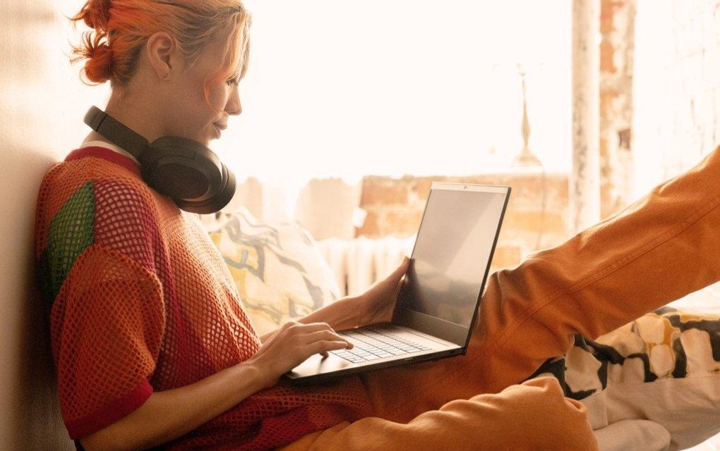 A woman lying on a bed using a laptop