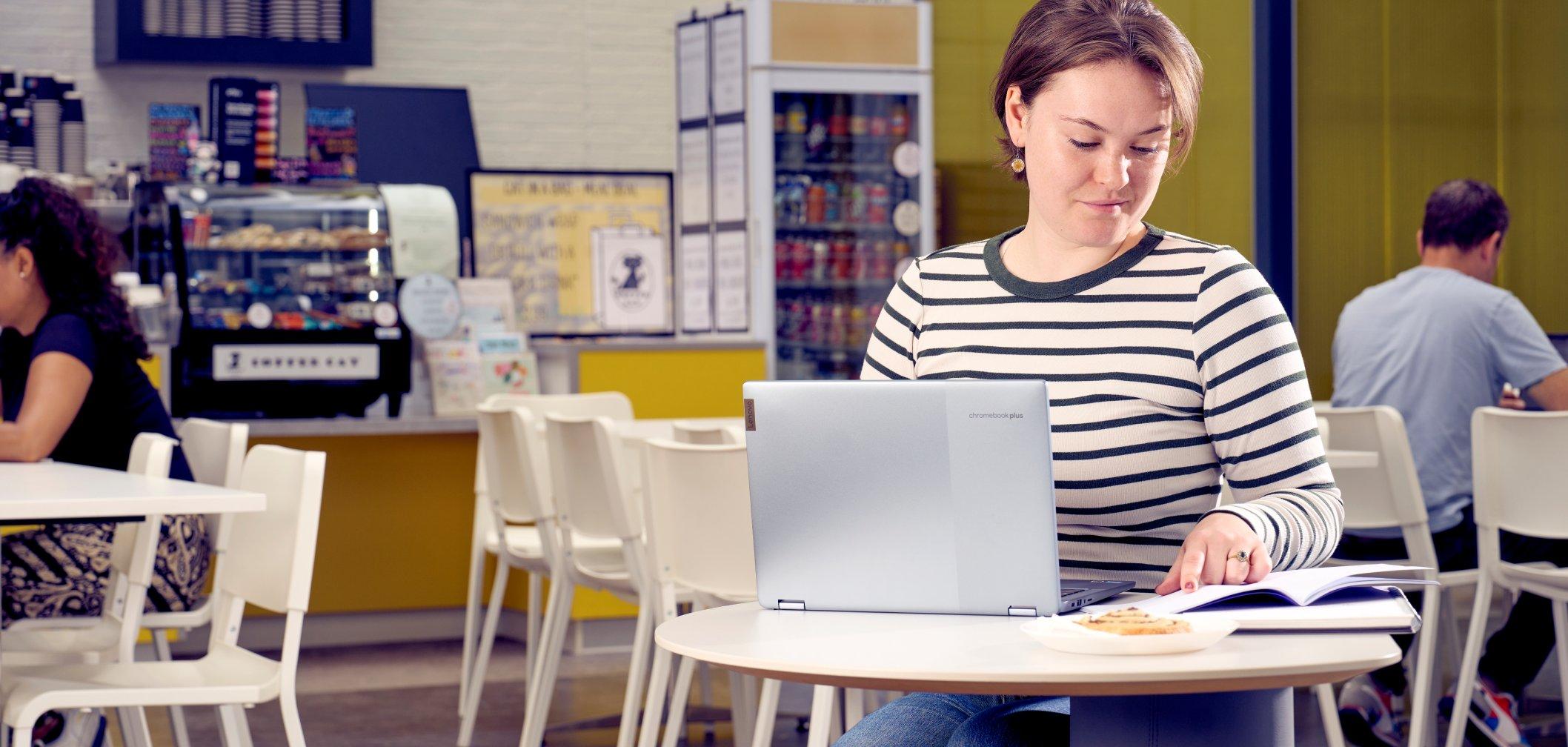 a woman sitting at a table with a laptop computer