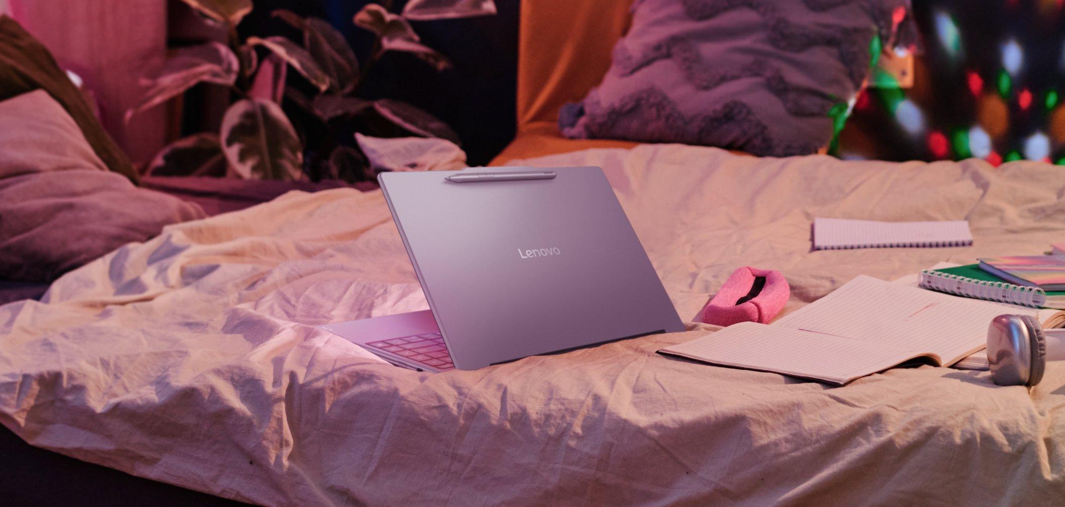 a laptop computer sitting on a bed with a bedspread