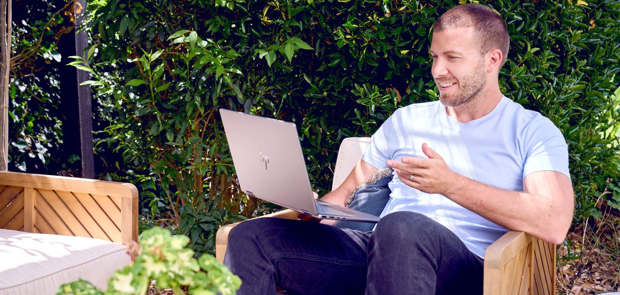 a man sitting in a chair with a laptop on his lap