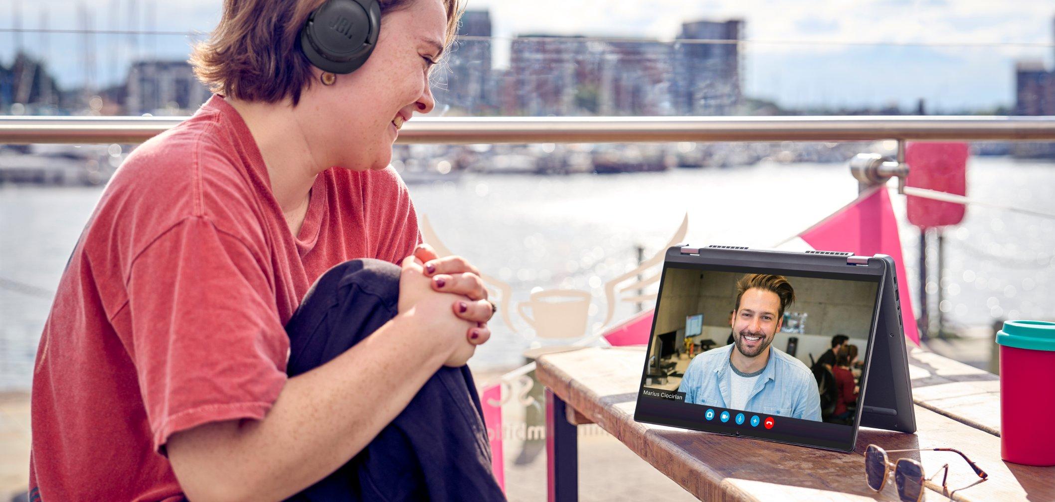 a woman sitting at a table with headphones on and a laptop