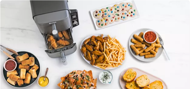 A table with a variety of food on it including french fries and bread