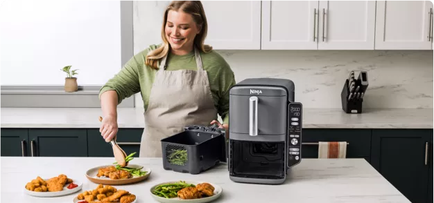 A woman preparing food in a kitchen with a food processor