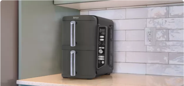 A black toaster oven sitting on a counter in a kitchen