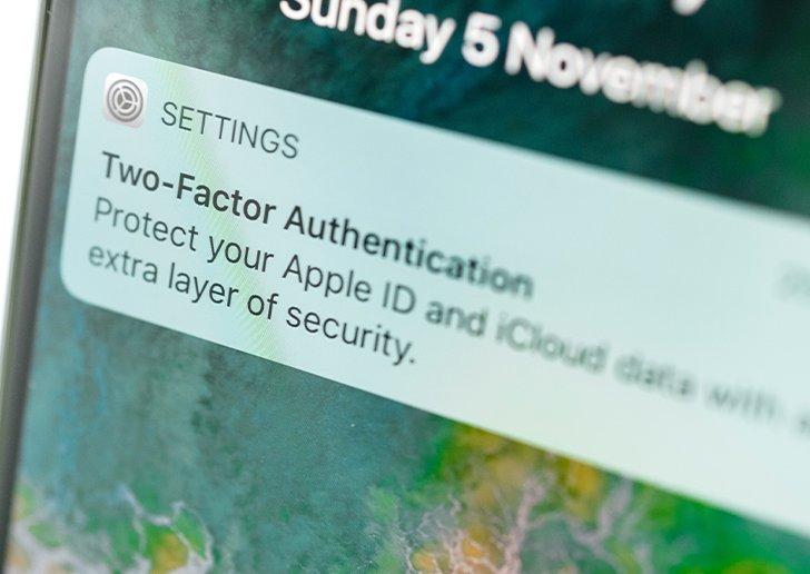 A close up of a mobile phone with a pop up on the screen for two-factor authentication
