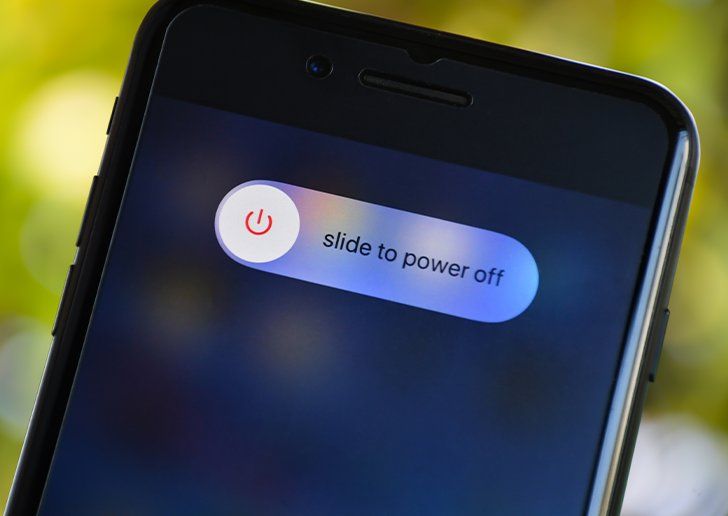 A close up of a mobile phone, a slide-to-power-off message is on the screen