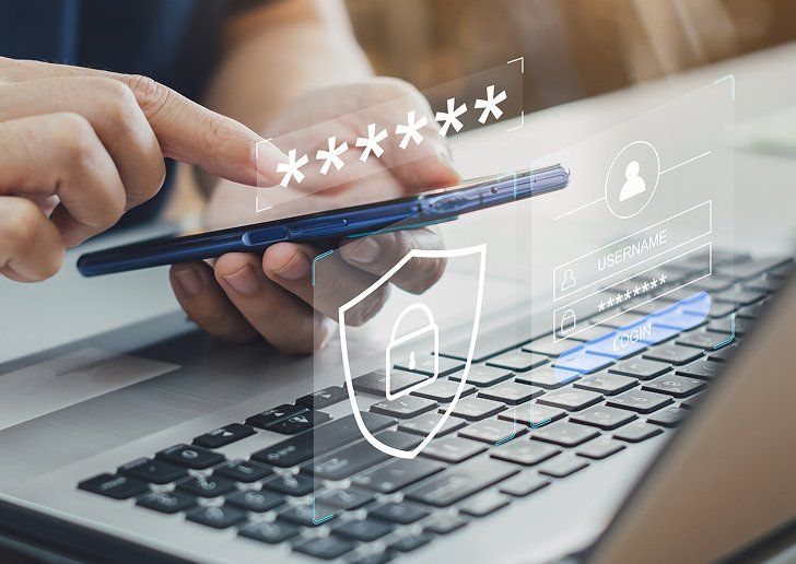A person holding a phone whilst using a laptop, with a secure icon and password overlaid on top