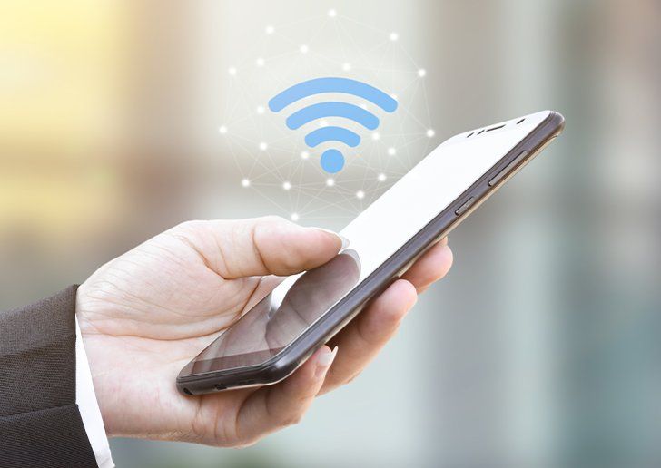 A person holding a phone, with a Wi-Fi icon overlaid on top