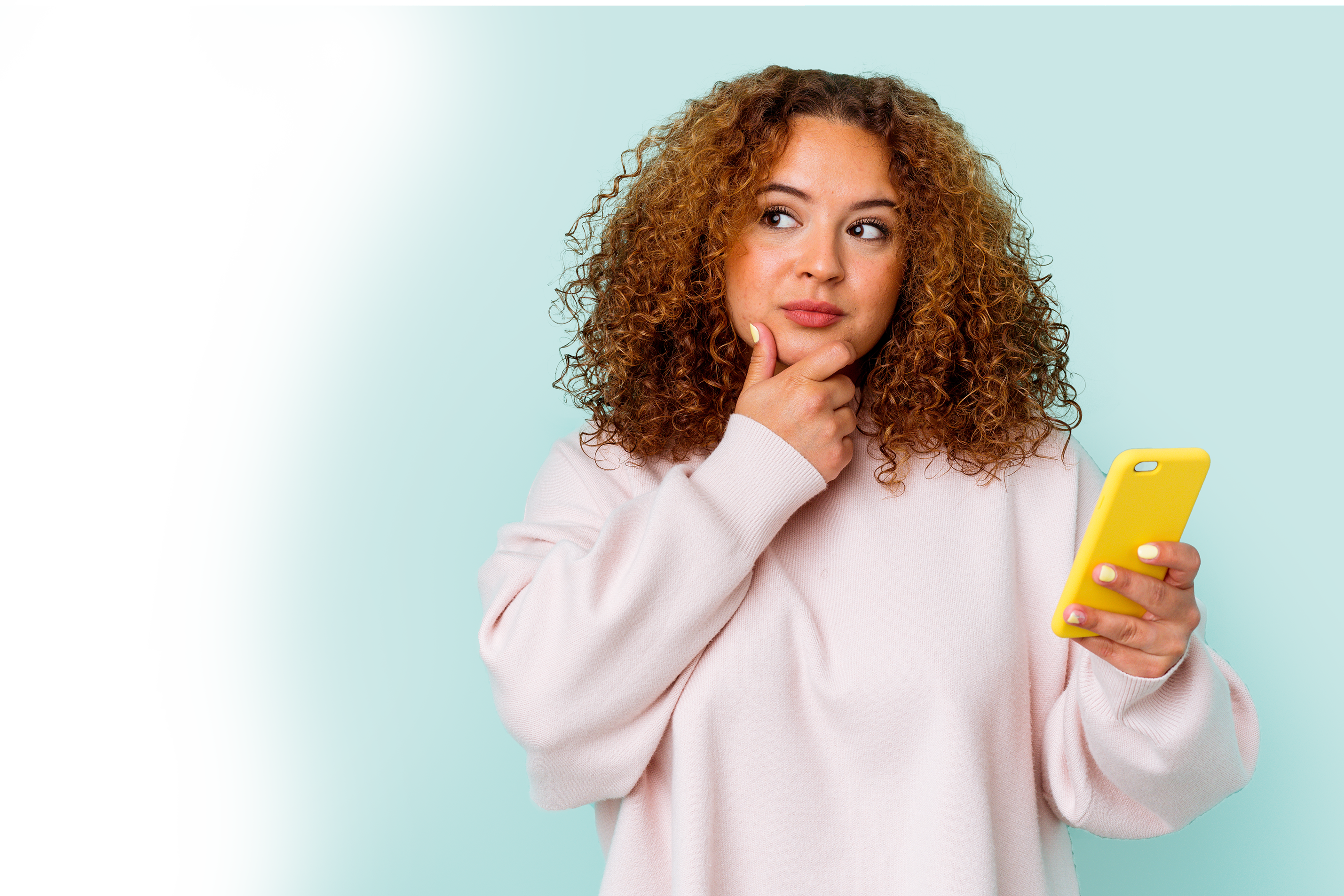 Woman looking thoughtful whilst holding a smart phone