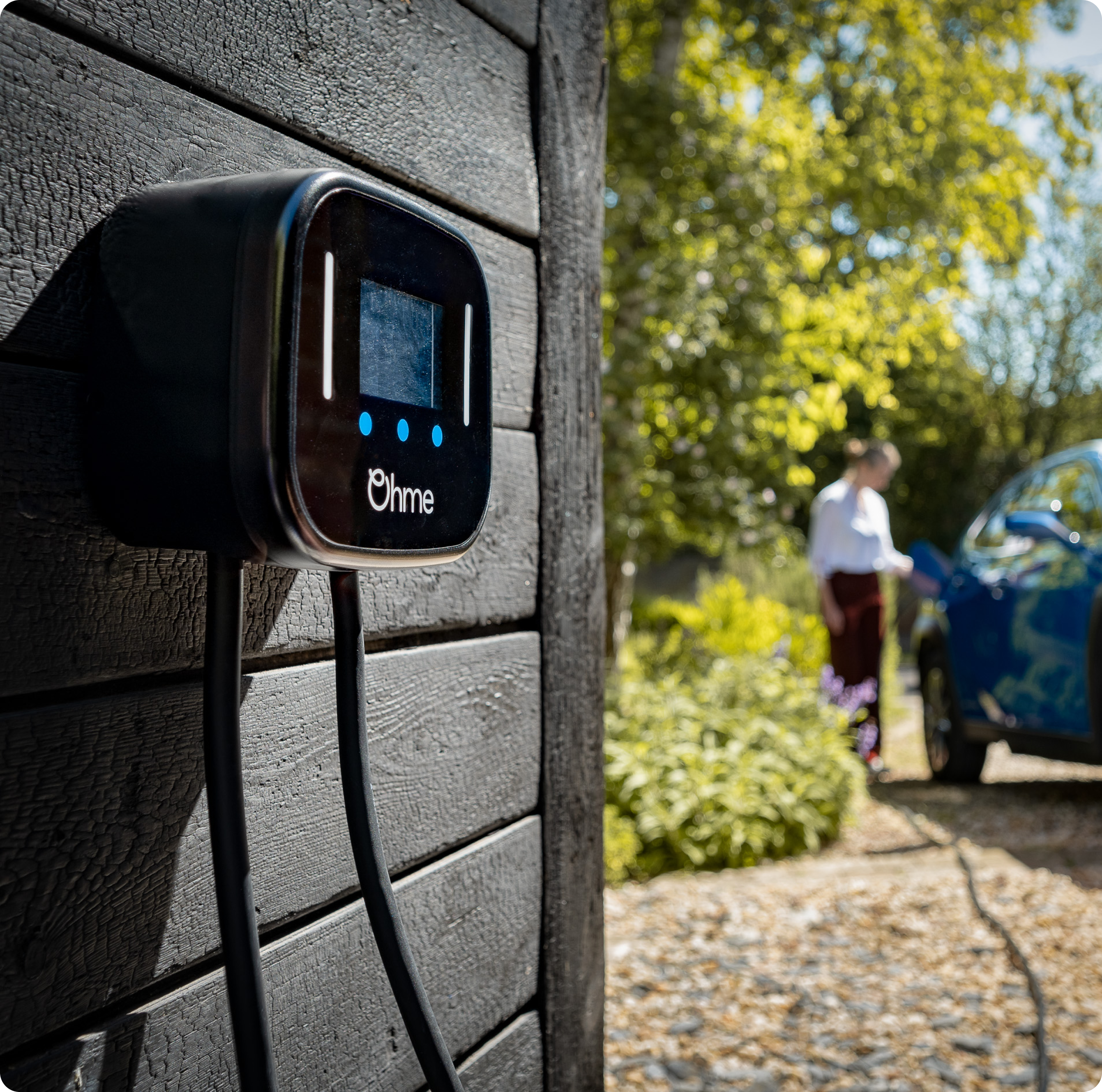 Electric car plugged into Ohme charger on wall